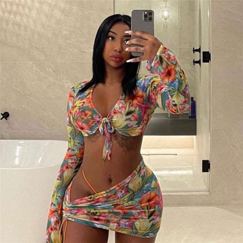3 Piece Floral Mesh Skirt Set Create an eye-catching look with this 3 Piece Floral Mesh Skirt Set. This set offers a cropped top with long sleeves and a tie front, allowing you to adjust the fit as desired. The breathable mesh material features a stunning